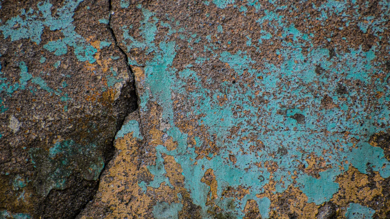 Cracked and corroded surface with peeling paint, representing slow invisible degradation