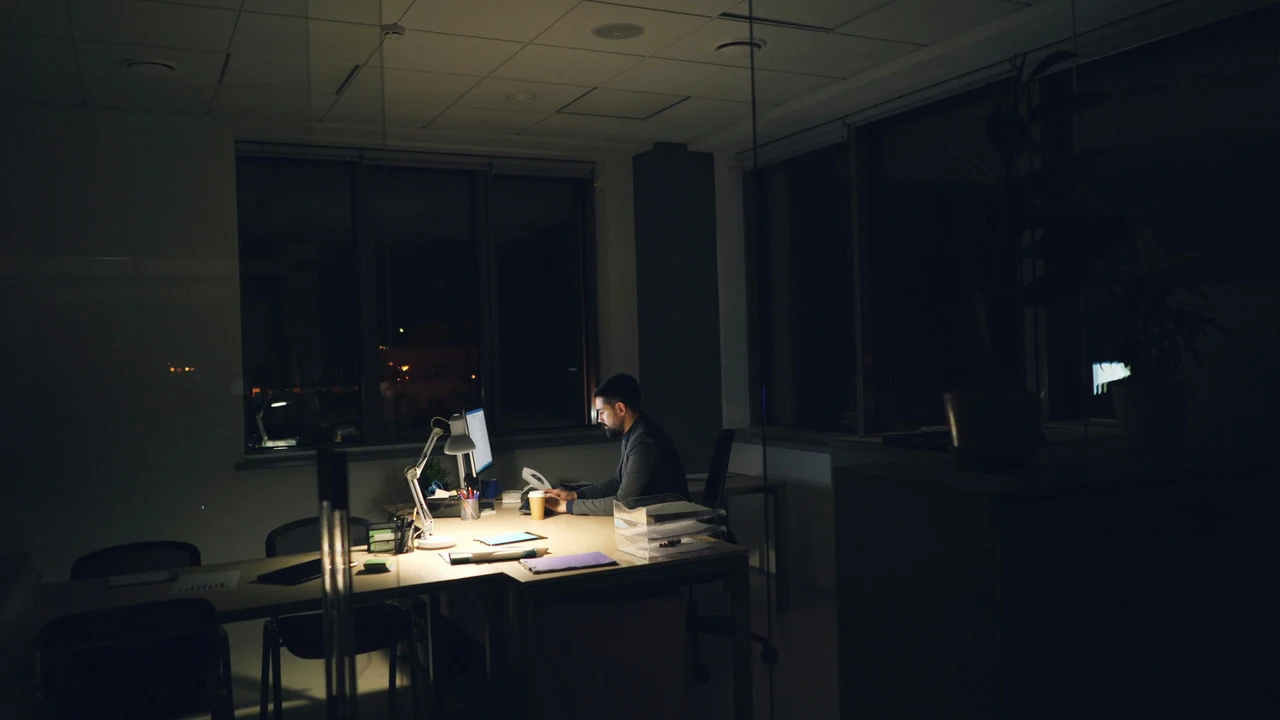 Person working alone at a desk late at night, representing the quiet shift of decision-making authority